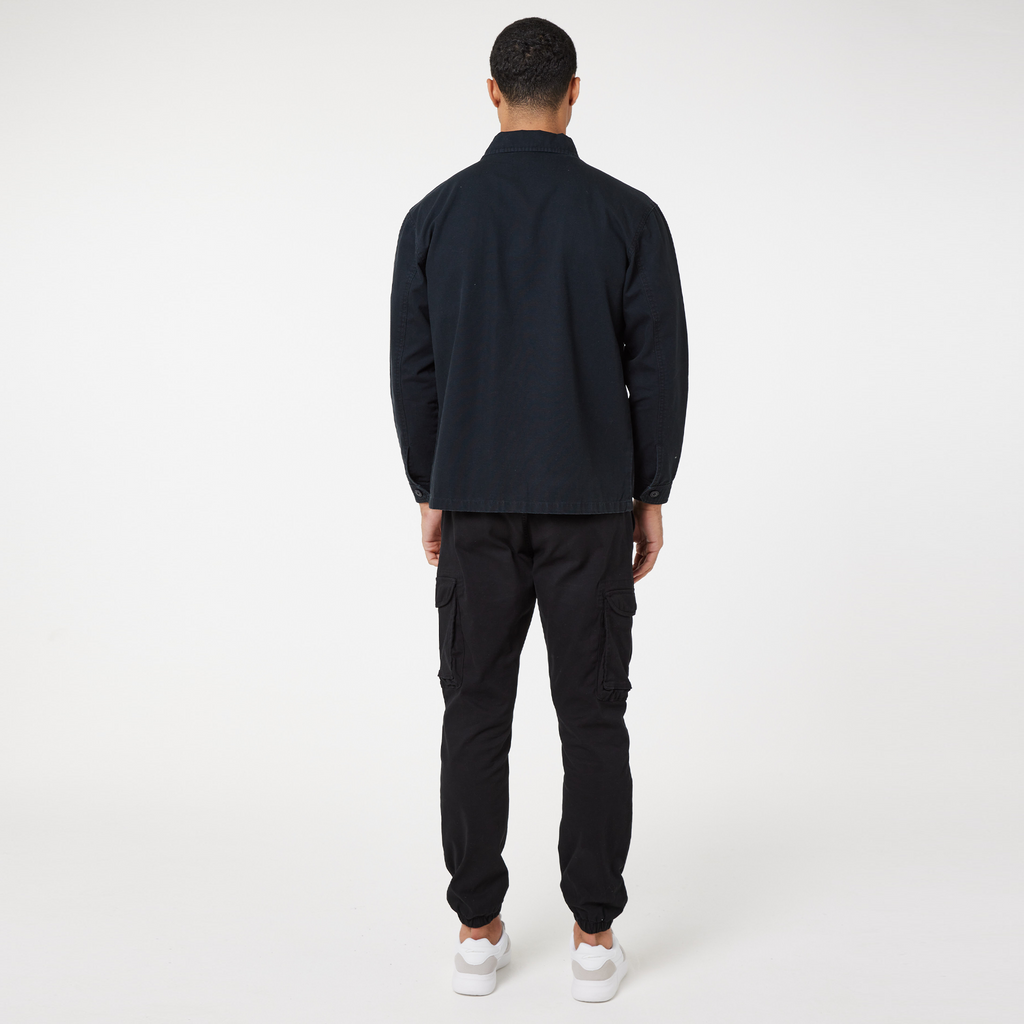 Back view of men's utility overshirt and black cargo pants