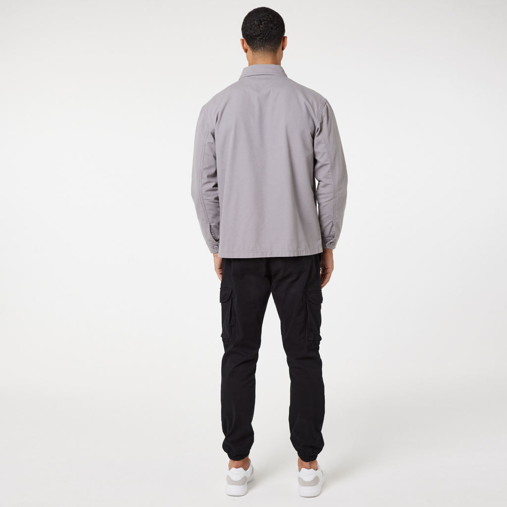 Back profile view of mid grey overshirt jacket and black cargo pants