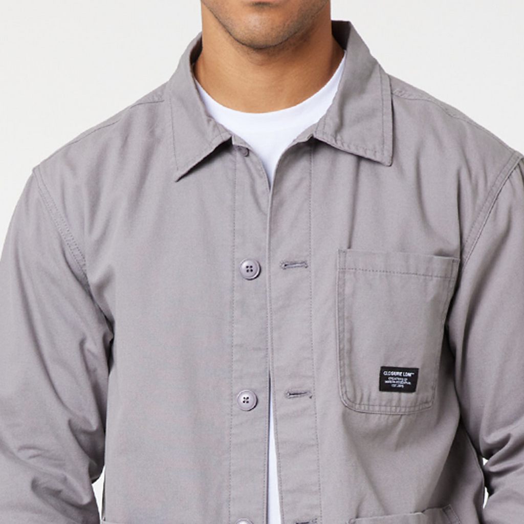 Close up of men's cargo overshirt jacket with grey buttons and black "CLOSURE LDN" logo