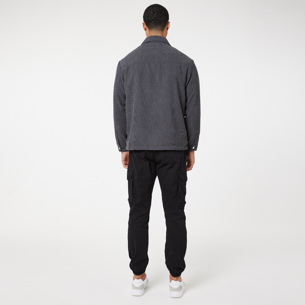 Back profile of corduroy overshirt in charcoal with black trousers