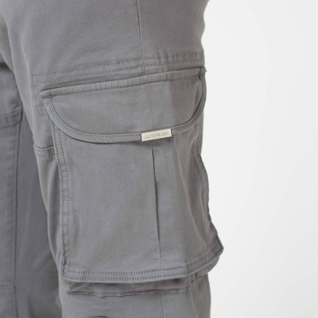 Utility cargo pants pocket with silver metal logo on pocket lid