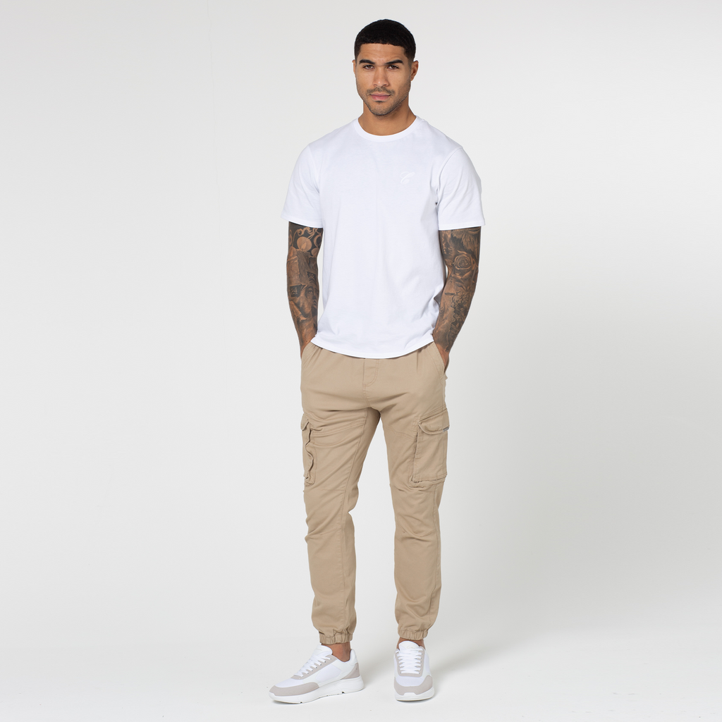 Full view of model wearing classic cargo pants in beige style with white men's short sleeved tee
