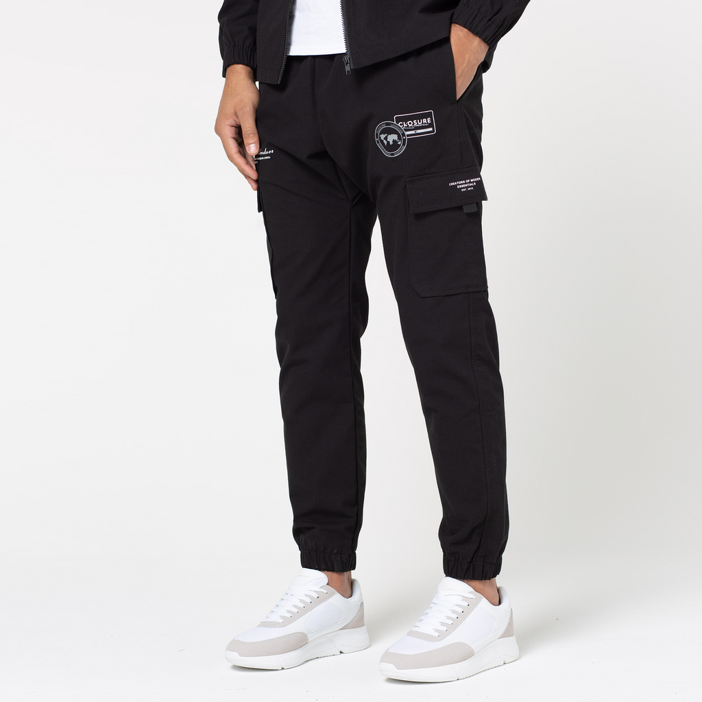 Model wearing Milano zip white logo cargo pants in black with cuffed feature
