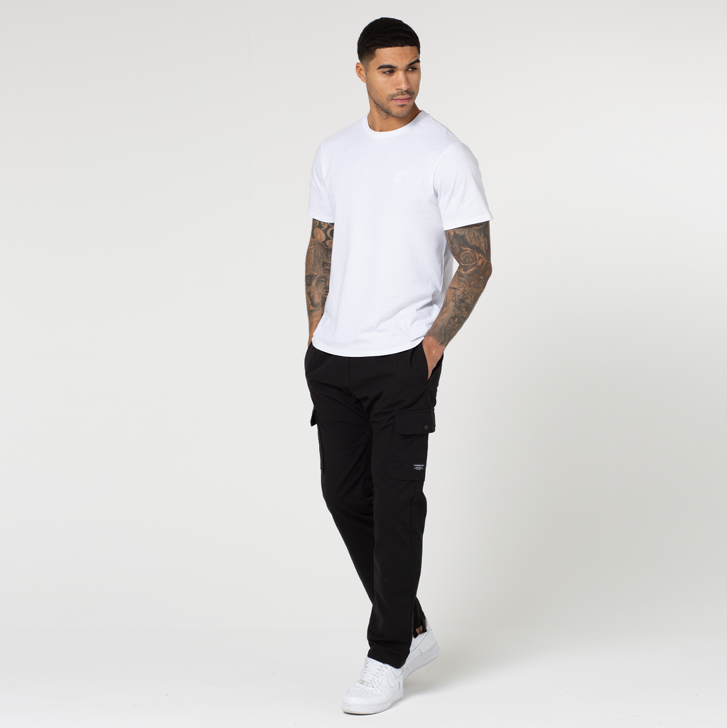 Men's open hem utility cargo pants with white short sleeved tee and trainers