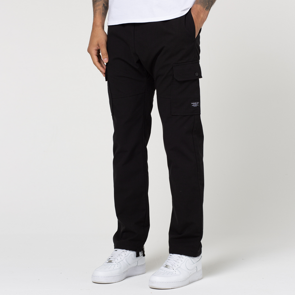 Black open hem cargo pants with adjustable strap styled with white trainers