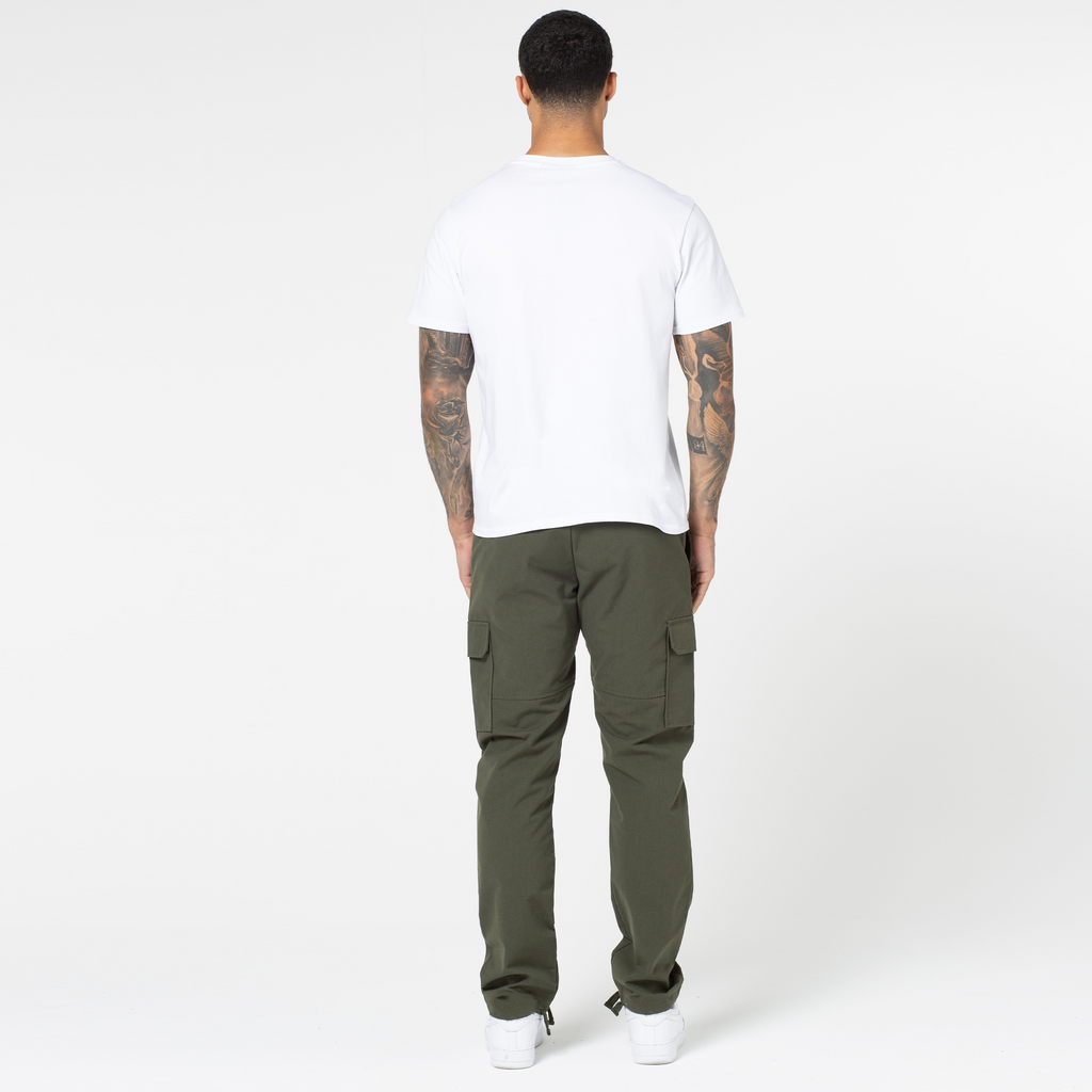 back profile of model green cargo pants paired with white top