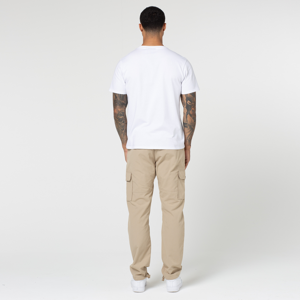 Back profile of beige open hem men's cargo pants with white top and trainers