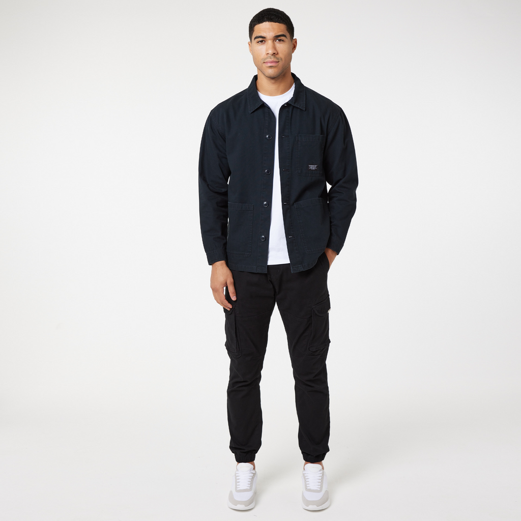 Black core jacket overshirt over white top styled with black cargo trousers