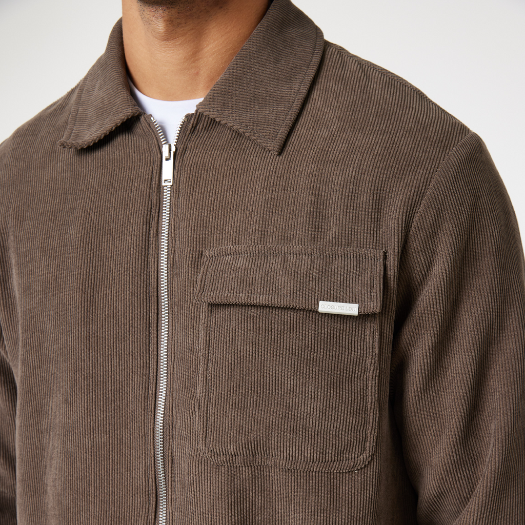 Zoomed in picutre up corduroy men's overshirt in brown showing "CLOSURE LDN" logo