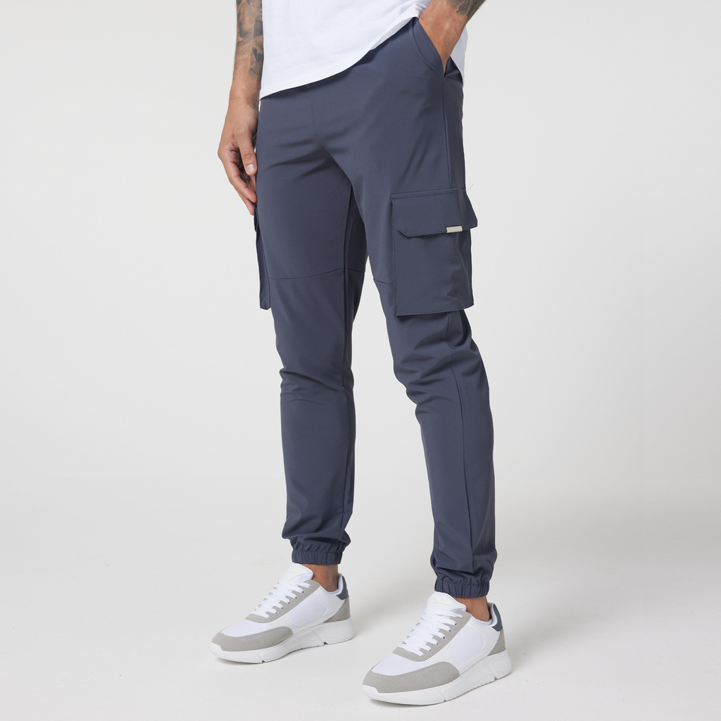 Men's charcoal cuffed utility cargo trousers with two pockets and paired with white casual trainers