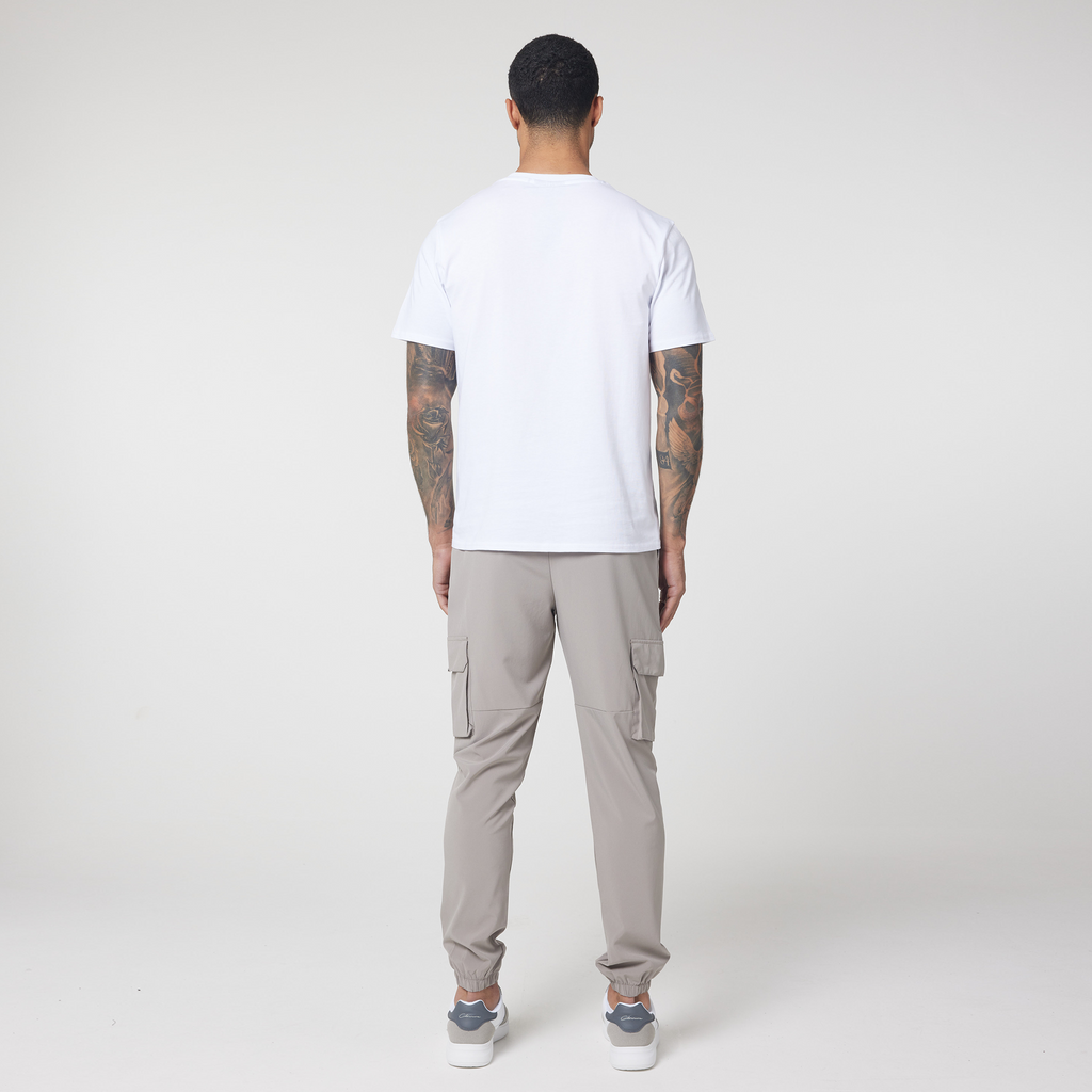 Back of men's tech cargo pants in stone with plain white t-shirt