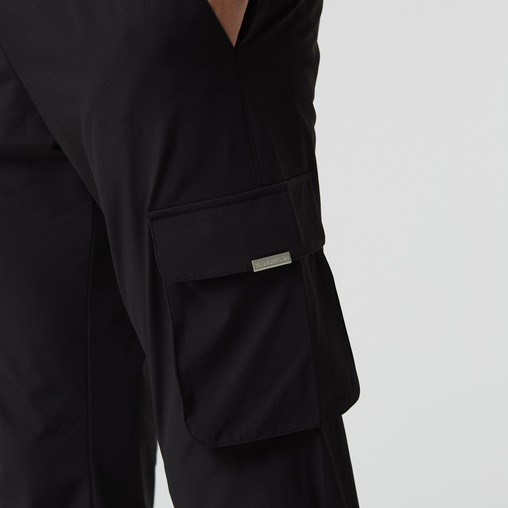 Close up of black utility trousers pocket with silver "CLOSURE LDN" logo