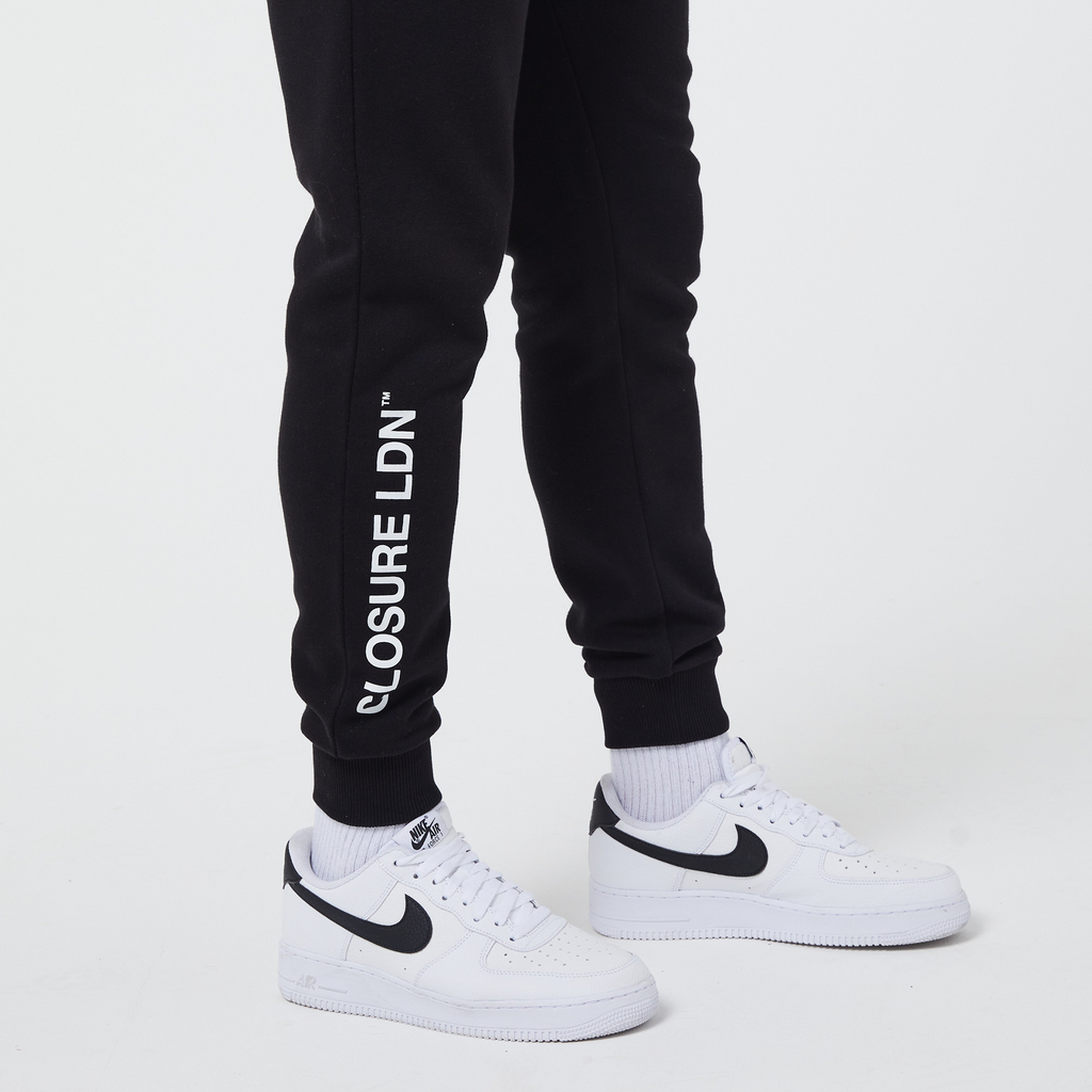 White Closure London branding on leg of black joggers